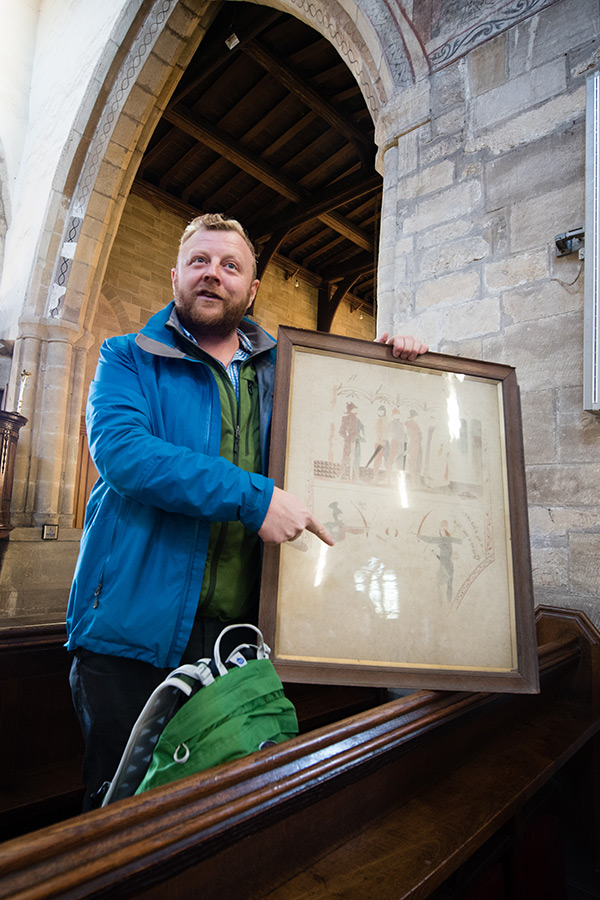 An Archaeology staff member discussing a painting in a historic building