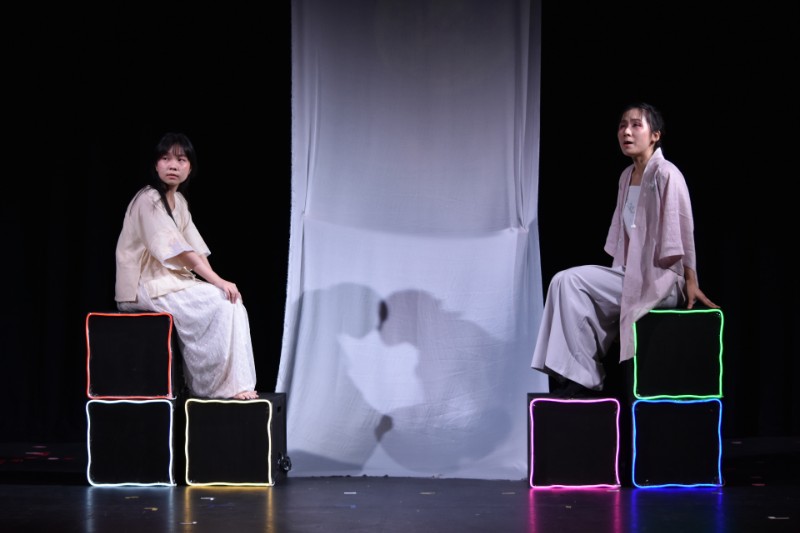 Two students sitting on theatre set