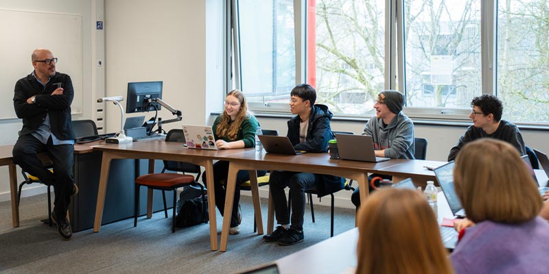 A group of students talking with an academic.