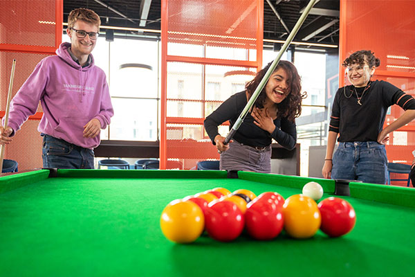 Three students playing pool in the Anne Lister reception