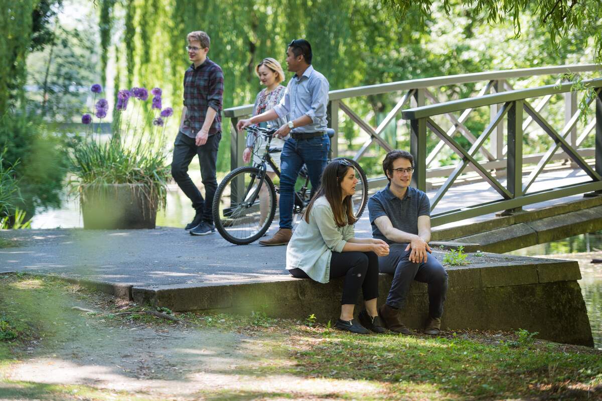 students walking around campus with a bike