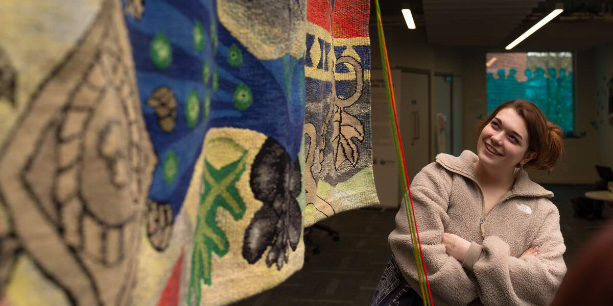 A student looking at art in the Spring Lane Building