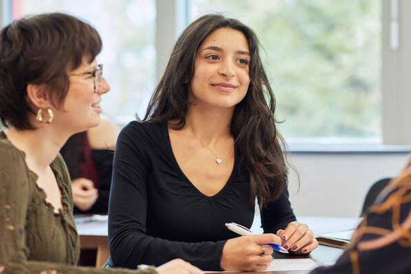 Student in a seminar with teacher and other student